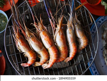 Close Up Shrimps Grilled On Sieve At Seafood Restaurant. Prawn Seafood Barbecue Are Cooking On Fire.