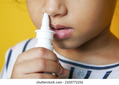 Close Up Of Sick Child Using Nasal Medicine Spray