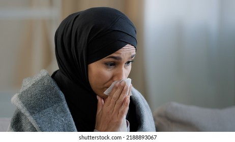 Close Up Sick Upset Young Girl In Hijab Sneeze Wipe Nose With Paper Napkin Sad Unhealthy Muslim Woman Drinking Hot Tea Suffering From Seasonal Cold Feel Virus Flu Symptoms Coronavirus Epidemic