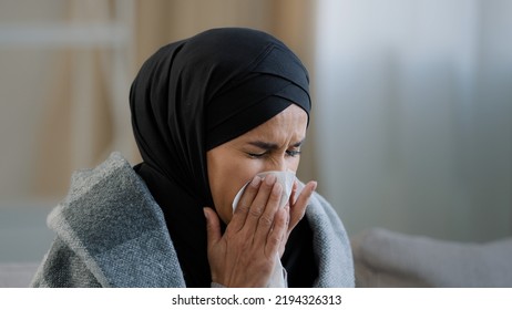 Close Up Sick Upset Young Girl In Hijab Sneeze Wipe Nose With Paper Napkin Sad Unhealthy Muslim Woman Drinking Hot Tea Suffering From Seasonal Cold Feel Virus Flu Symptoms Coronavirus Epidemic