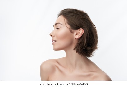 Close Up Side Face Portrait Of Young Naked Graceful Smiling Brunette Lady With Blunt Bob. Isolated On White