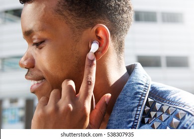 Close Up Side Portrait Of Attractive Man Listening To Music With Finger To Ear