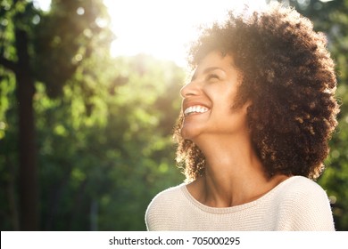 Close up side portrait of beautiful confident woman laughing in nature