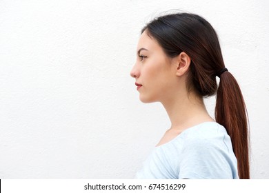 Close up side portrait of casual young woman standing alone