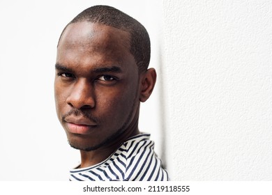 Close Up Side Portrait Serious African American Man Leaning Against White Wall