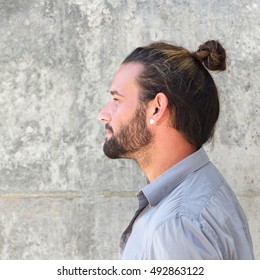 Close Up Side Portrait Of Serious Man With Beard And Hair Bun