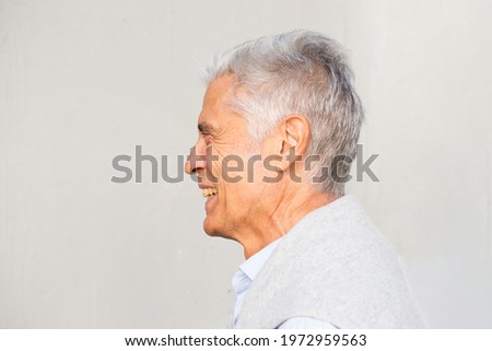 Close up side portrait smiling elderly man against white background
