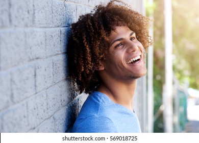 Close up side portrait of young man laughing outside