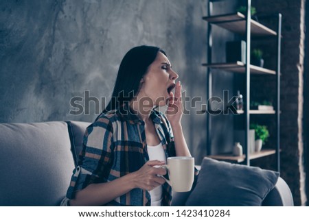 Close up side profile photo beautiful she her lady covered blanket just woke up hands arms hot beverage yawn Monday six o'clock wear checkered plaid shirt sit cosy divan flat house living room indoors