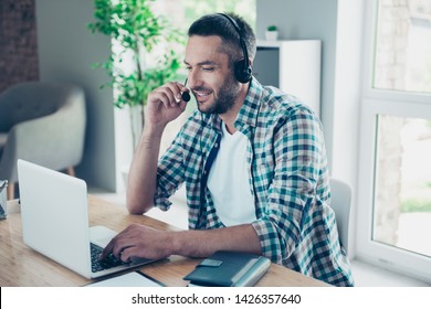 Close up side profile photo handsome he him his guy headset speak microphone customer answer questions help assist buyer call center notebook table desk sit office chair wear plaid checkered shirt - Powered by Shutterstock