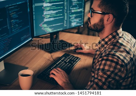Close up side profile photo handsome he him his guy linux windows cross platform coder typing php css keyboard development outsource IT monitors table office agency wear specs formalwear plaid shirt