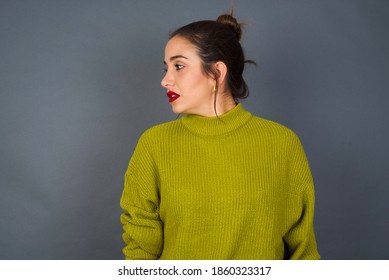 Close Up Side Profile Photo Young Beautiful Hispanic Woman Wearing Green Sweater Against Gray Background Not Smiling Attentive Listen Concentrated