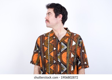 Close Up Side Profile Photo Young Caucasian Man Wearing Generic Pattern Printed Shirt Against White Wall  Not Smiling Attentive Listen Concentrated