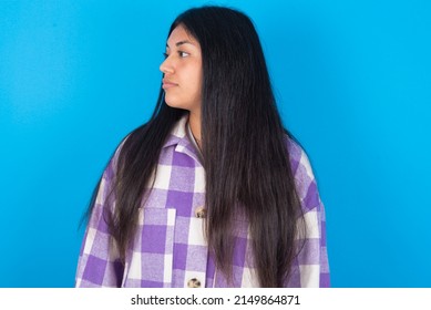 Close Up Side Profile Photo Young Hispanic Woman Wearing Plaid Shirt Over Blue Background Not Smiling Attentive Listen Concentrated