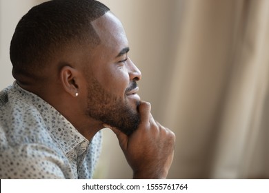 Close up side profile view of happy dreamy african American male look in distance thinking visualizing, smiling biracial man dreaming imagining future career opportunities, planning perfect life - Powered by Shutterstock