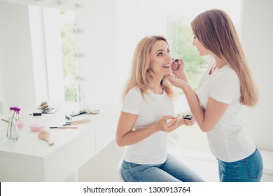 Close up side profile view photo two people mum teen daughter excited glad weekend communicate doing indoors makeup applying cheekbone wear white t-shirts jeans bright flat apartment room place - Powered by Shutterstock