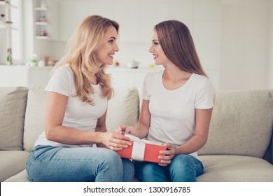 Close Up Side Profile View Photo I Have Gift For You Two People Mum And Teen Daughter Holding Hands Arms Red Box Ribbon Bow Surprise Wear White T-shirts Jeans In Bright Flat Sit On Cozy Sofa