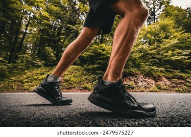 Close up side shot of a  runners legs while running on a country asphalt road in fall - Powered by Shutterstock