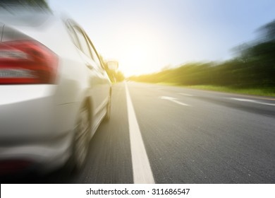 Close Up Side Of  Silver Car And Light On The  Road