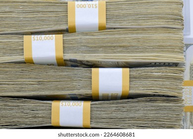 Close up side view of 4 straps of ten thousand one hundred US dollar bills stacked on top of each other