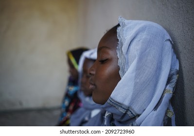 Close Up Side View African Black Woman Sit By Wall Indoors Look Down Sad Indoors. Copy Space Human Rights Concept Background