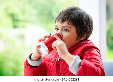 Close Up Side View Of Cute Little Boy Drinking Soda, Kid Boy Looking Out Of Window With Thinking Of Something While Drinking Soft Drink, Unhealthy Food And Drink For Children Concept