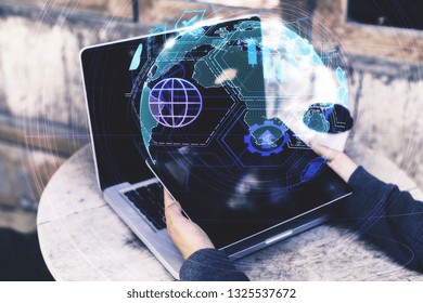 Close up and side view of hands using laptop with digital globe interface on blurry background. Distributed data and internet concept. Double exposure 