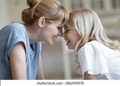 Close Up Side View Happy Laughing Mother And Little Daughter Touching Foreheads, Enjoying Tender Moment, Overjoyed Beautiful Young Mum And Adorable Child Cuddling, Good Family Relationship