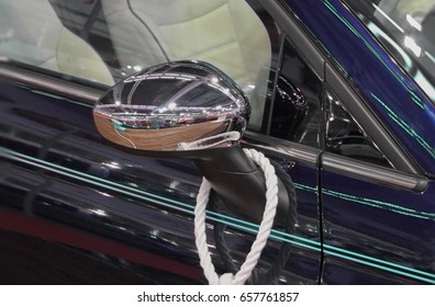 The close up of side view mirror of navy blue car.