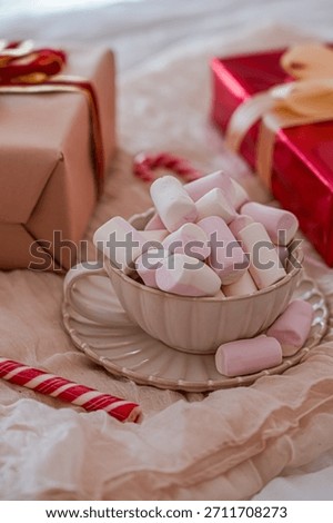 Close Up Side View of Mug with Marshmallows and Gift Boxes in Background