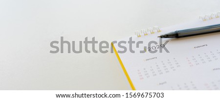 close up side view on  white calendar schedule background with pen to make appointment meeting or manage timetable each day for planning work in new year 2020 resolution concept