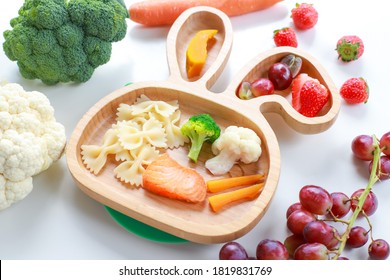 Close Up Side View Of Plate Salmon,vegetable With Pasta And Fruit Healthy Nutrition For Baby Self-feeding Baby Led Weaning. Dish Of Finger Food For Kid.