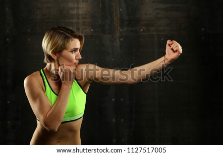 Similar – Close up side view profile portrait of one young athletic woman shadow boxing in sportswear in gym over dark background, looking away