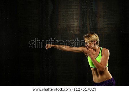 Image, Stock Photo Close up side view profile portrait of one young athletic woman shadow boxing in sportswear in gym over dark background, looking away
