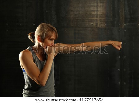 Similar – Close up side view profile portrait of one young middle age athletic woman shadow boxing in sportswear in gym over dark background, looking away