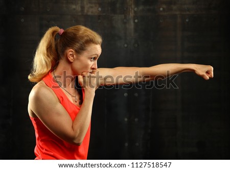 Similar – Close up side view profile portrait of one young middle age athletic woman shadow boxing in sportswear in gym over dark background, looking away