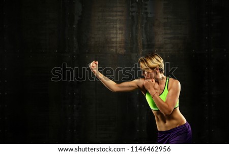 Similar – Close up side view profile portrait of one young athletic woman shadow boxing in sportswear in gym over dark background, looking away