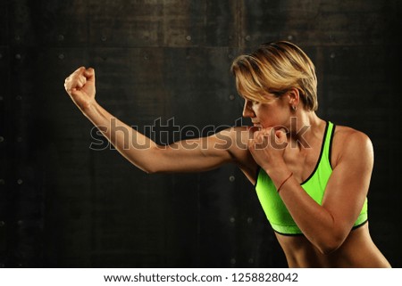 Similar – Close up side view profile portrait of one young athletic woman shadow boxing in sportswear in gym over dark background, looking away