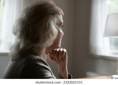 Close up side view of sad pensive old Caucasian woman look in window distance thinking pondering. Unhappy middle-aged female feel depressed distressed, suffer from solitude loneliness at home. - Powered by Shutterstock