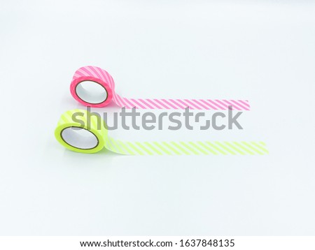Close up side view of straps paper tape in neon yellow and pink, stick on the surface, lay flat and isolated on white background with copy space.