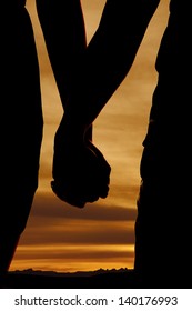 A close up of a silhouette of a couple holding hands.
