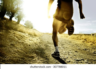 Close Up Silhouette Legs And Feet Of Extreme Cross Country Man Running And Training On Rural Track Jogging At Sunset With Harsh Sunlight And Lens Flare In Countryside Sport And Healthy Lifestyle