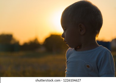 Close up silhouette portrait of little boy in profile at sunset