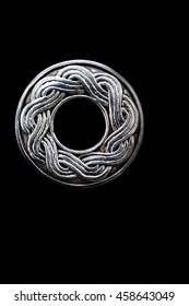 Close up of a silver celtic type symbol