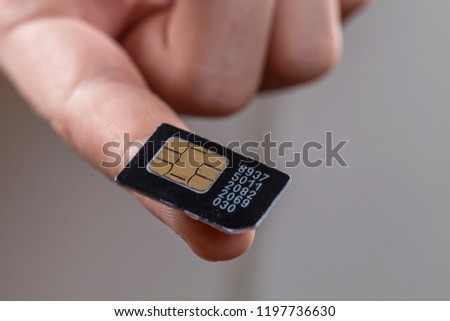 Close - up of the SIM card lying on the boy's finger.