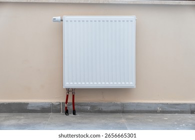 Close up of a simple panel radiator on a white wall.