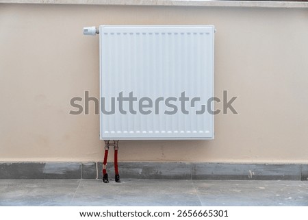 Close up of a simple panel radiator on a white wall.