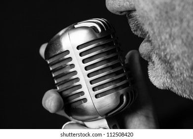 Close Up Of A Singers Mouth Singing Into A Vintage Microphone With A Black Background