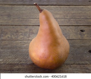 Close Up Of Single Bosc Pear On Rustic Wood Table