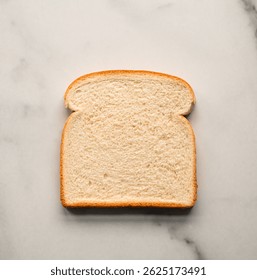 Close up of single slice of white bread isolated on marble counter.